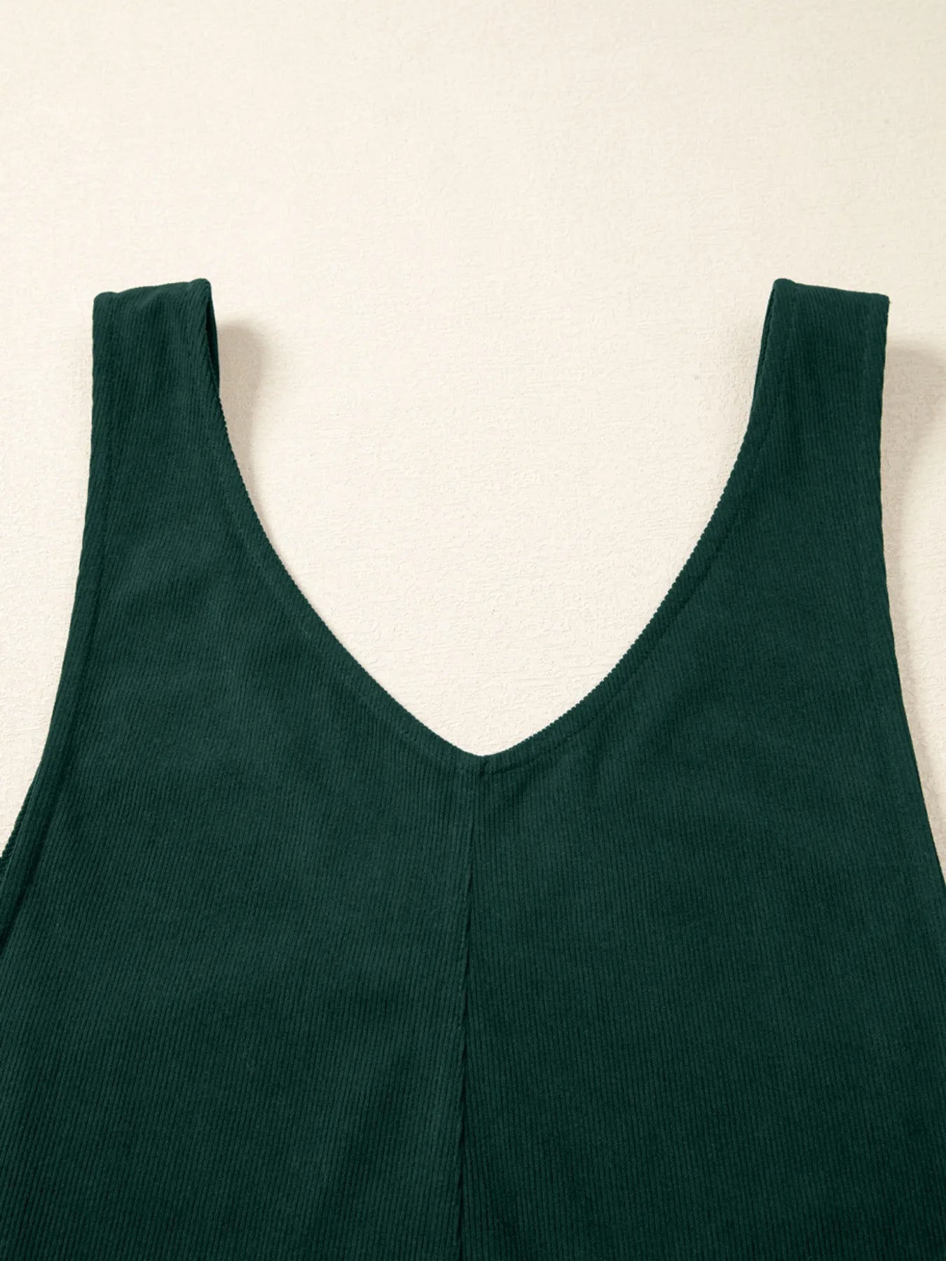 Dark green ribbed knit tank top with deep V-neck in jumpsuit