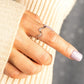 Hand wearing a wavy silver ring with cz accents