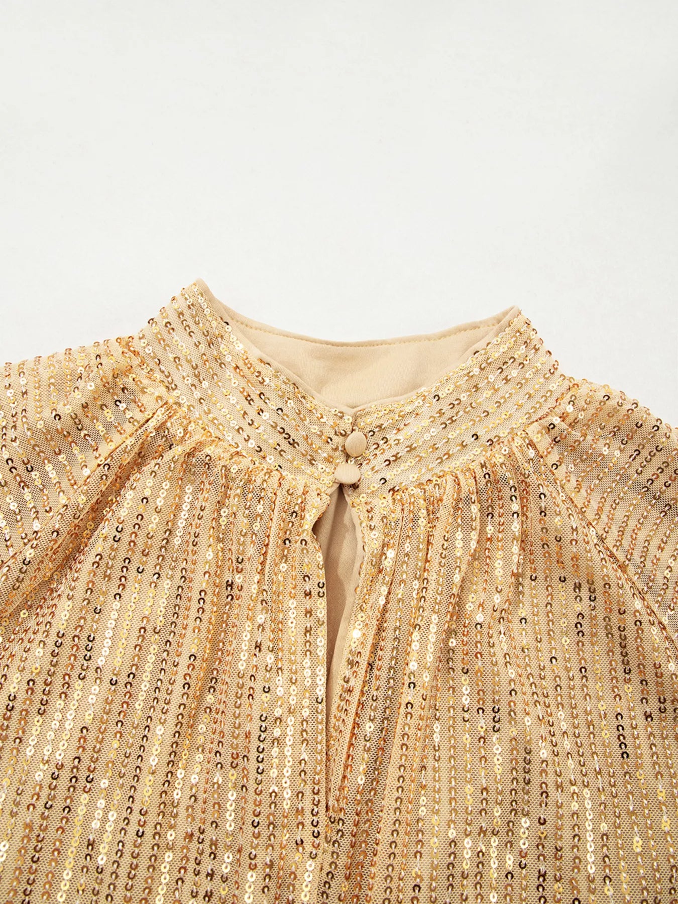 Gold sequined blouse with high neckline, button closure, and balloon sleeves