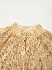 Gold sequined blouse with high neckline, button closure, and balloon sleeves