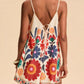 Floral print spaghetti strap romper in cream with vibrant red orange blue blossoms