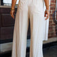 Cream-colored wide-leg drawstring pants with relaxed fit and front pockets