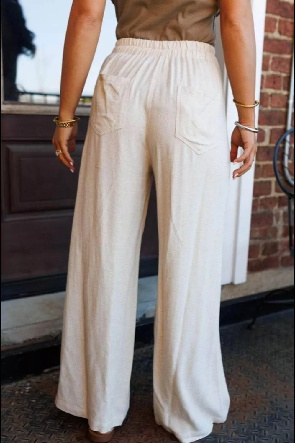 Cream-colored wide-leg drawstring pants with relaxed fit and front pockets