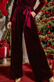 Burgundy velvet wide-leg jumpsuit with bow tie waist