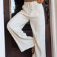 Cream-colored high-waisted wide-leg drawstring pants with button closure
