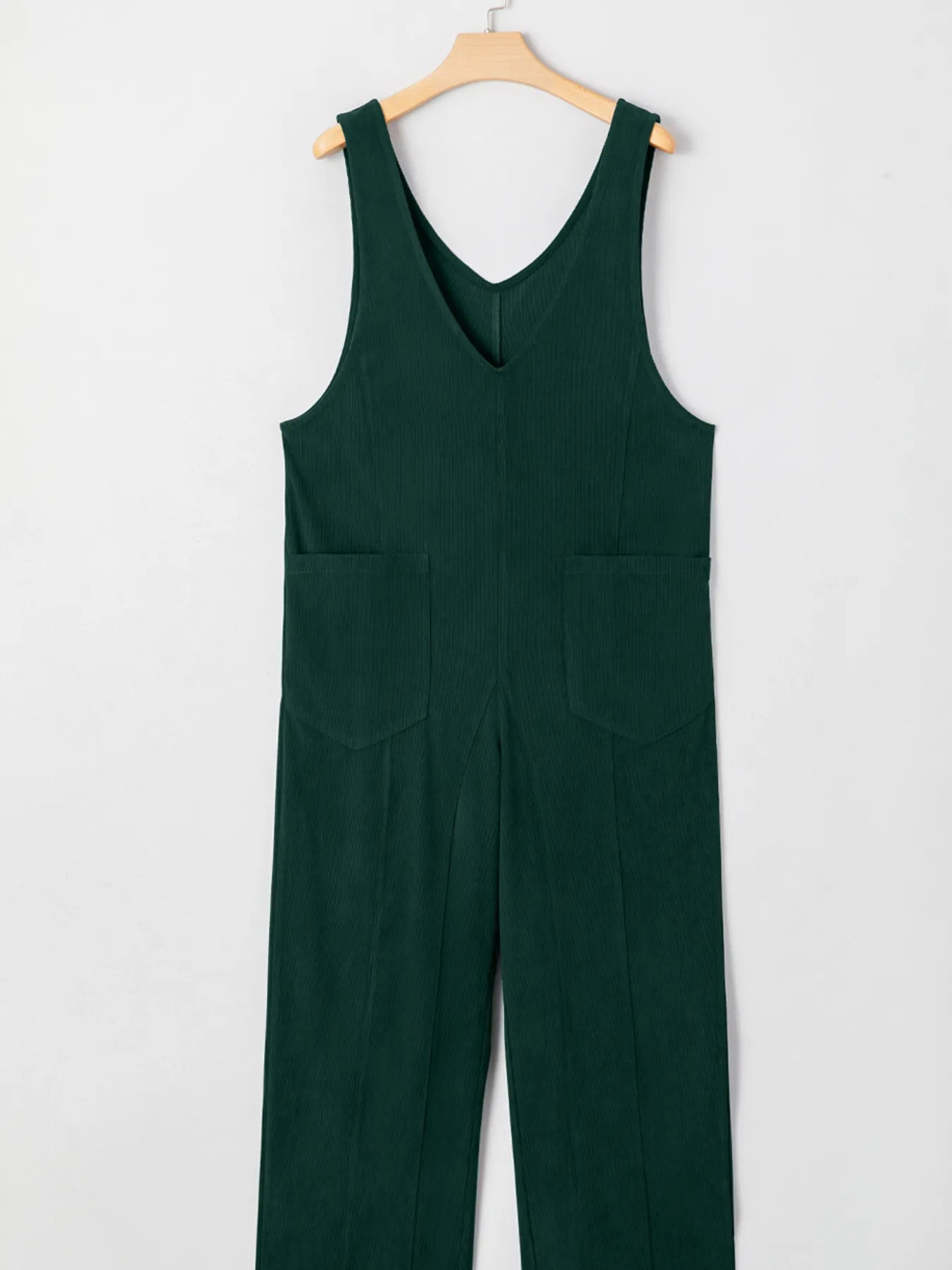 Dark green sleeveless corduroy jumpsuit with V-neck and patched pockets