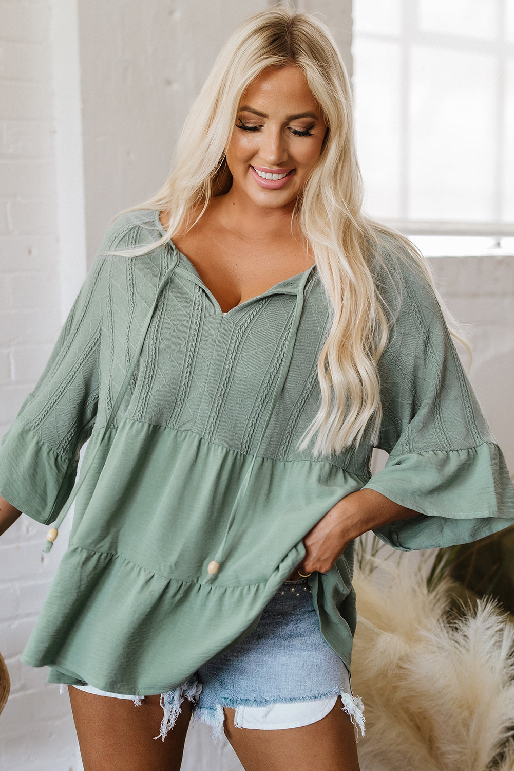 Soft sage green loose-fitting V-neck blouse with ruffled sleeves