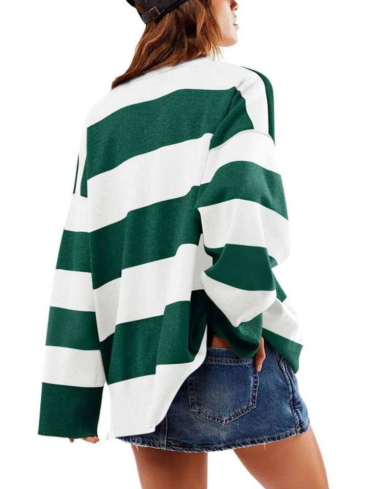 Green and white striped sweater worn by a person on a white background