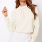 Cream-colored ruched mock neck long sleeve blouse with pleated collar