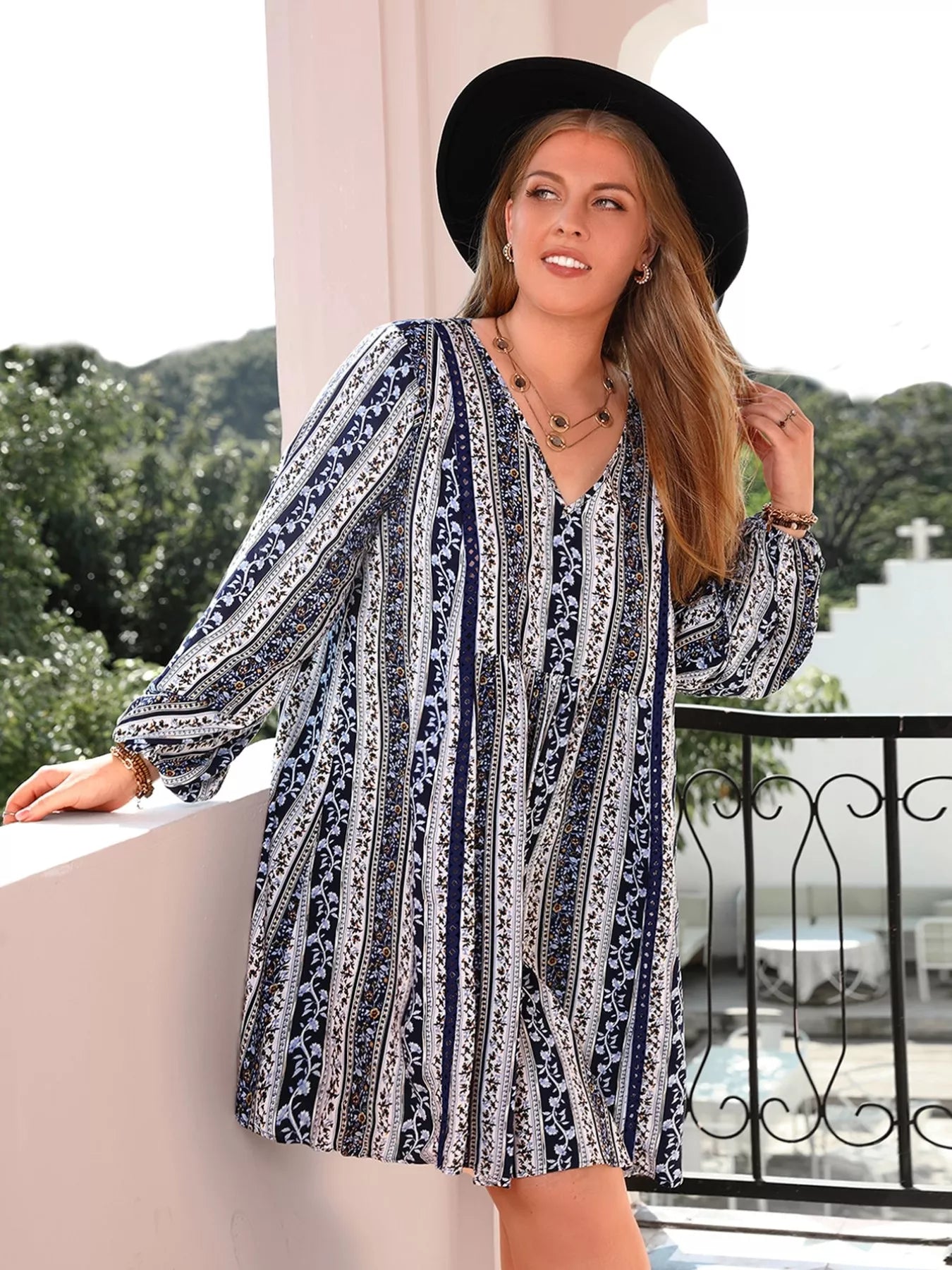 Woman in plus size boho print V-neck long sleeve mini dress