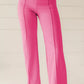 Bright pink high-waisted bootcut pants with straight-leg cut and vertical seams