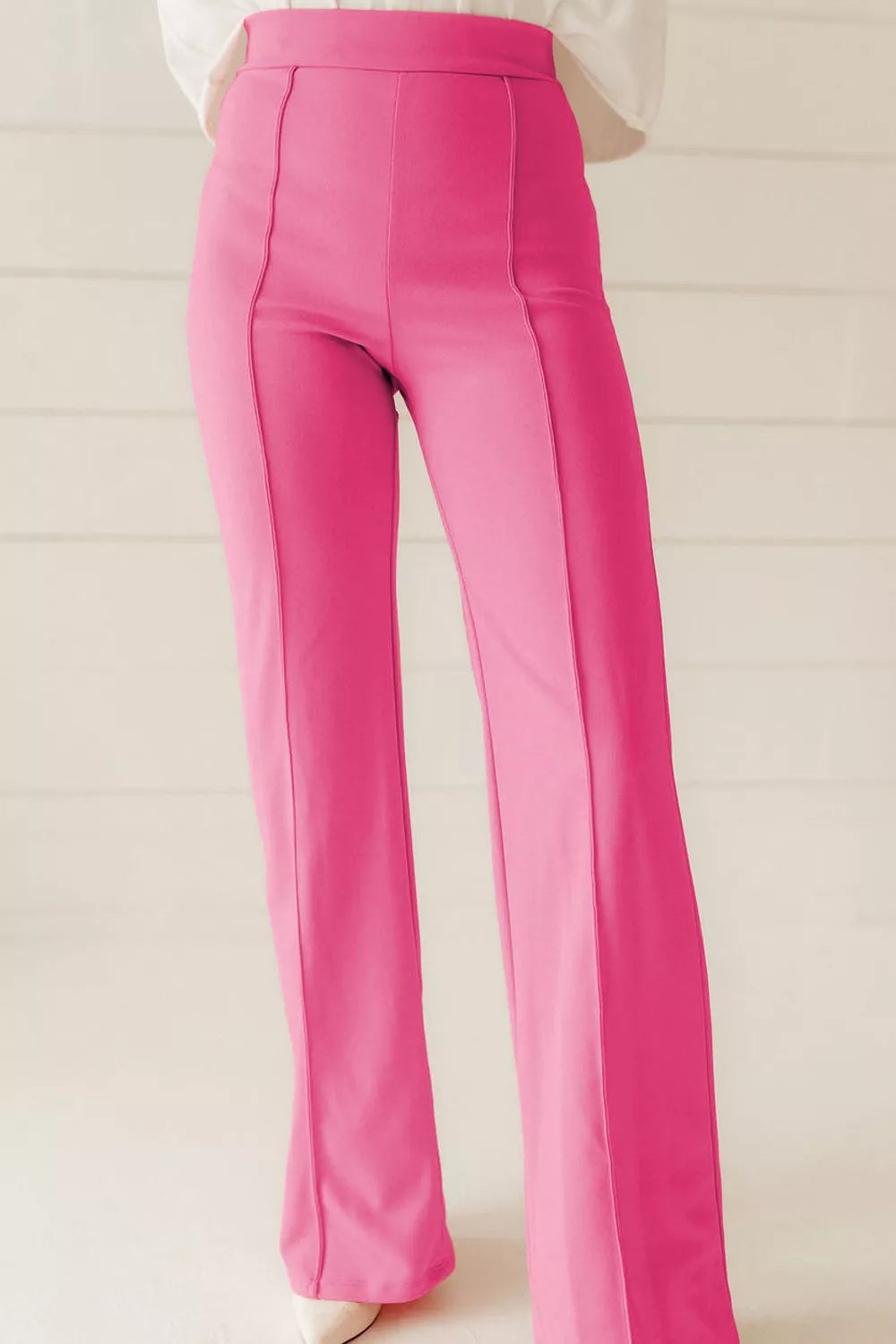 Bright pink high-waisted bootcut pants with straight-leg cut and vertical seams