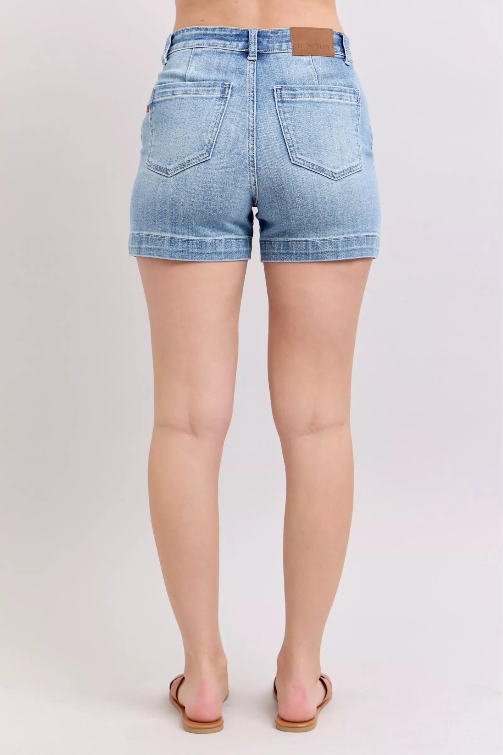 Back view of Judy Blue mid-rise light-wash denim shorts with leather patch