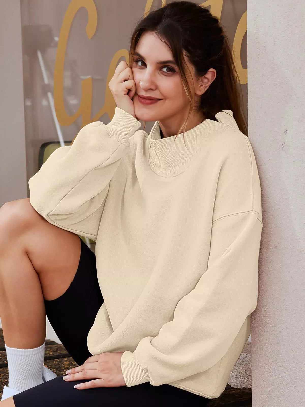 Cream-colored mock neck dropped shoulder sweatshirt with relaxed fit and ribbed cuffs