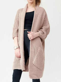 Woman wearing a blush-pink Chunky Knit Open Front Cardigan with a textured waffle weave and deep front pockets, styled over a black top.