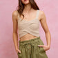 Beige crocheted crop top with thin straps over twill shorts