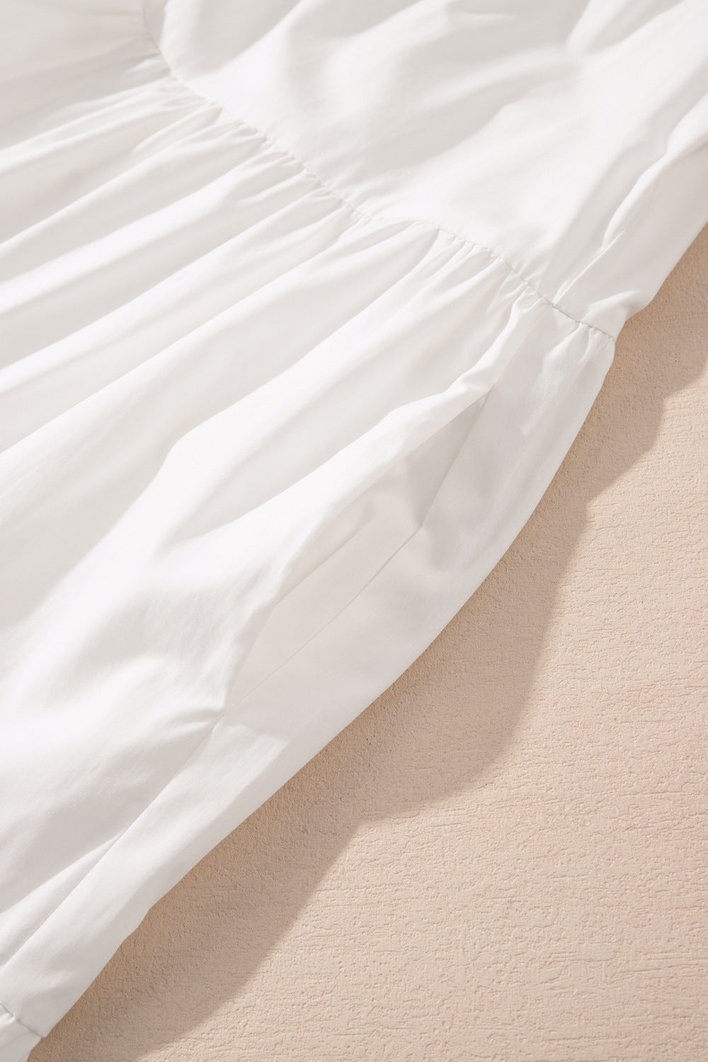 White ruffled 3/4 sleeve tiered mini dress fabric with soft pleats and gathered waistline