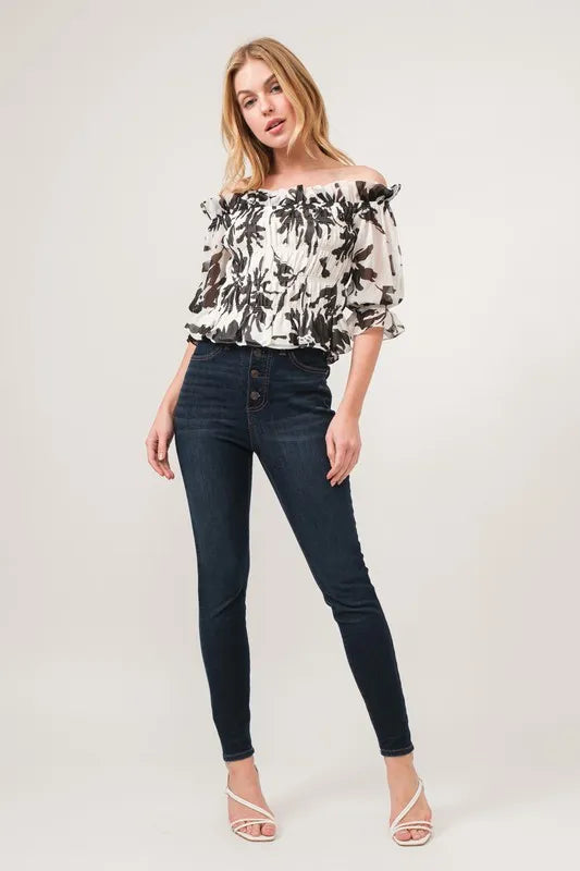 Black high-waisted slim fit jeans with button fly and floral top