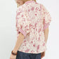 Woman in Umgee mixed print puff sleeve split neck top with pink floral blouse