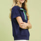 Navy blue Umgee short-sleeved collared top with green white striped trim