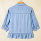 Back view of Daverri light blue chambray shirt with ruffled hem cuffs embroidered patch