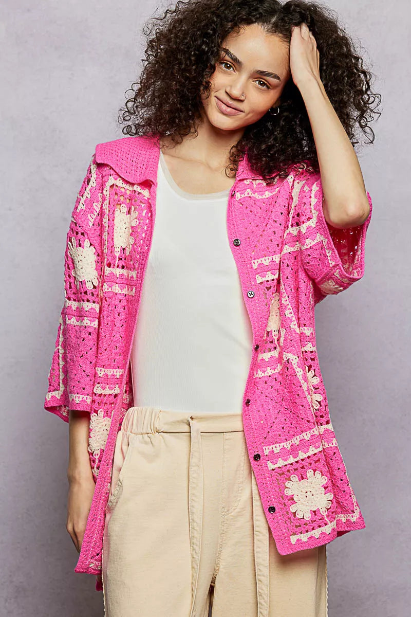 Vibrant pink crochet cardigan with white floral granny square patterns