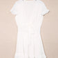 White tie-front mini dress with smocked waist, v-neck and ruffled hem