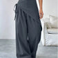 Daverri wrap-front wide-leg pants in dark gray with draped asymmetrical design
