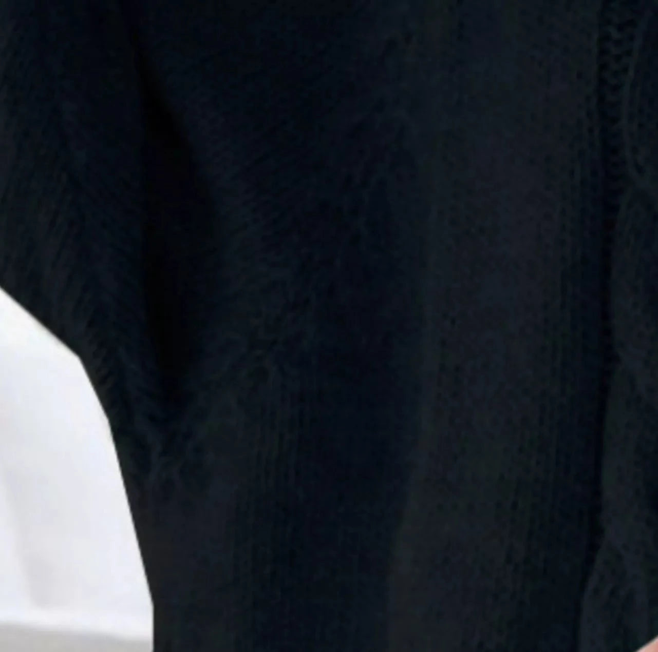 Black textured fabric sleeve on full-size cable-knit long sleeve sweater plus size