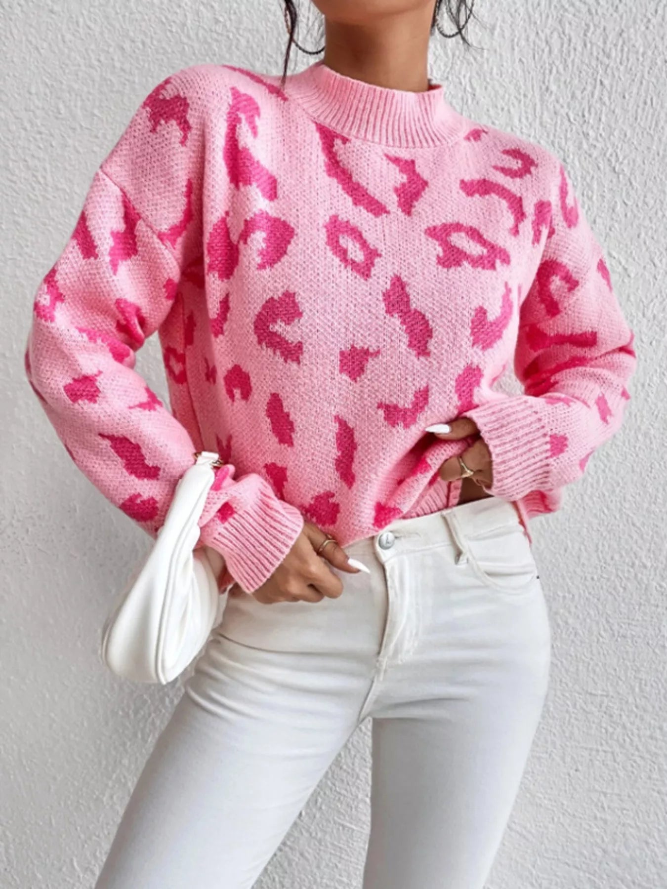 Pink leopard print mock neck sweater with white jeans and clutch