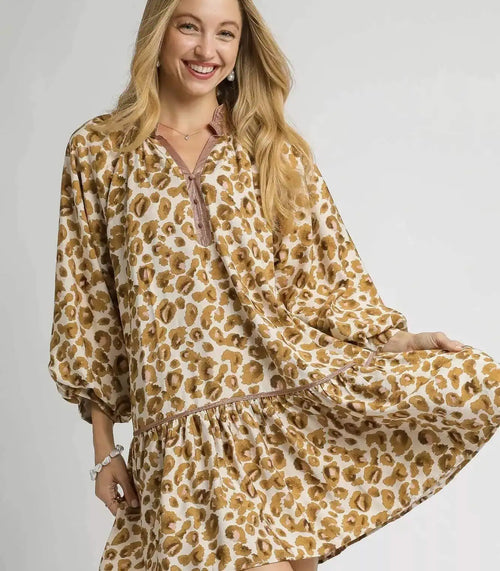 Woman wearing a leopard print dress against a plain background