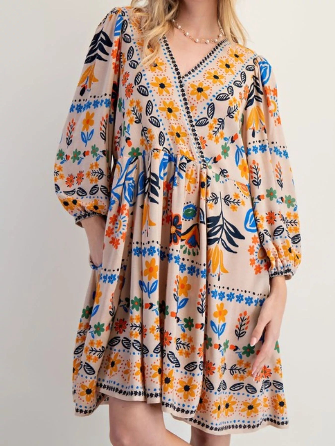 Vibrant bohemian floral print long sleeve mini dress in beige with orange, blue, green, black patterns