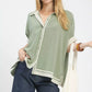 Mint-colored, lightweight blouse with contrasting white trim and button closure.