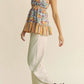 Woman in Davi & Dani floral smocked ruffle halter top and cream trousers