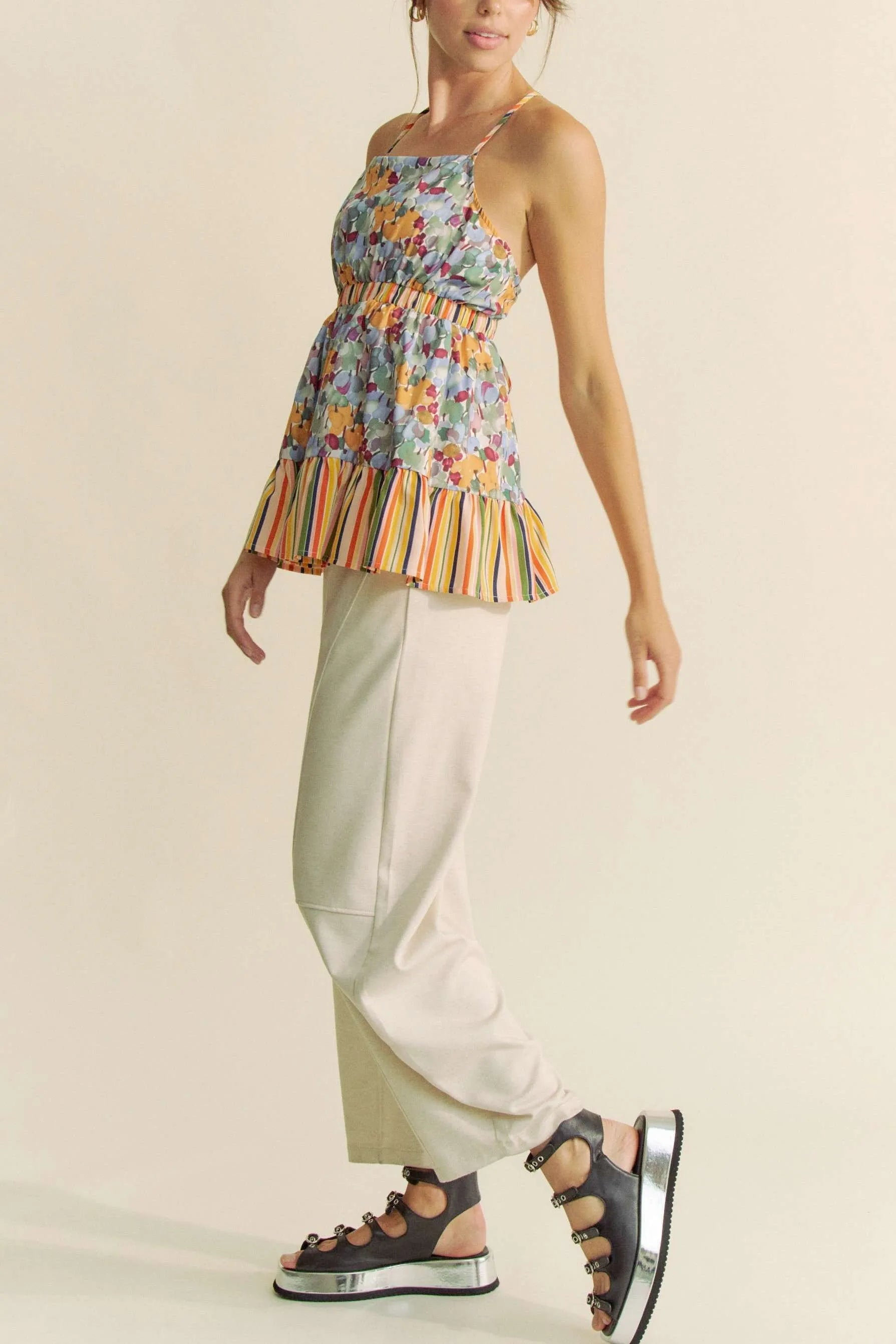 Woman in Davi & Dani floral smocked ruffle halter top and cream trousers