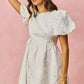 White textured mini dress with puff sleeves and floral jacquard