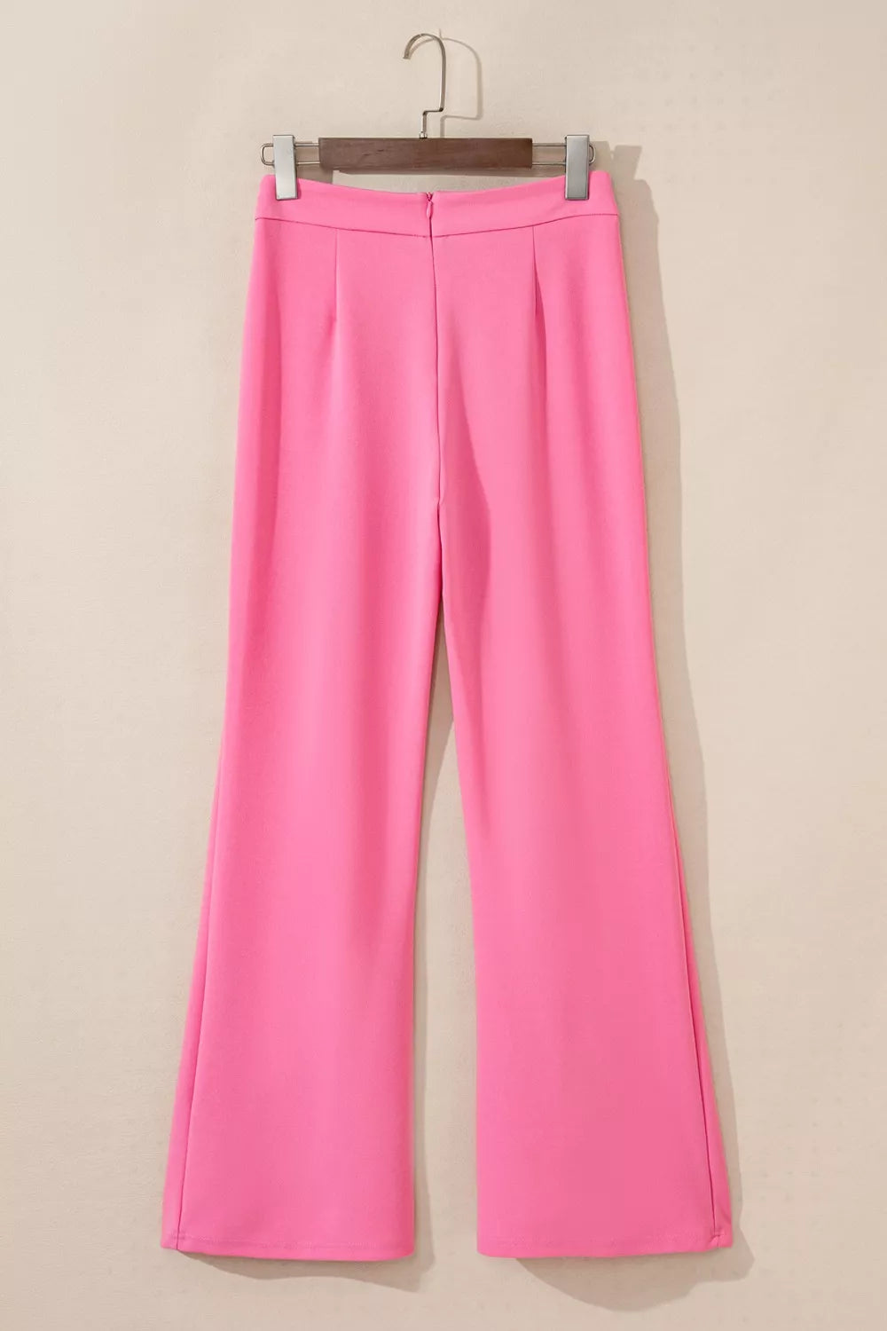 Bright pink high-waisted bootcut pants with pleated waistband