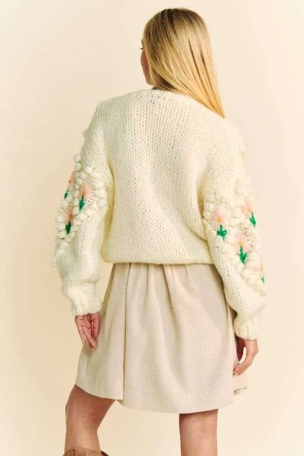 Cream knit sweater with pom-poms on sleeves in Davi & Dani floral cardigan