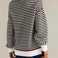 Black and white striped round neck long sleeve knit sweater with red trim
