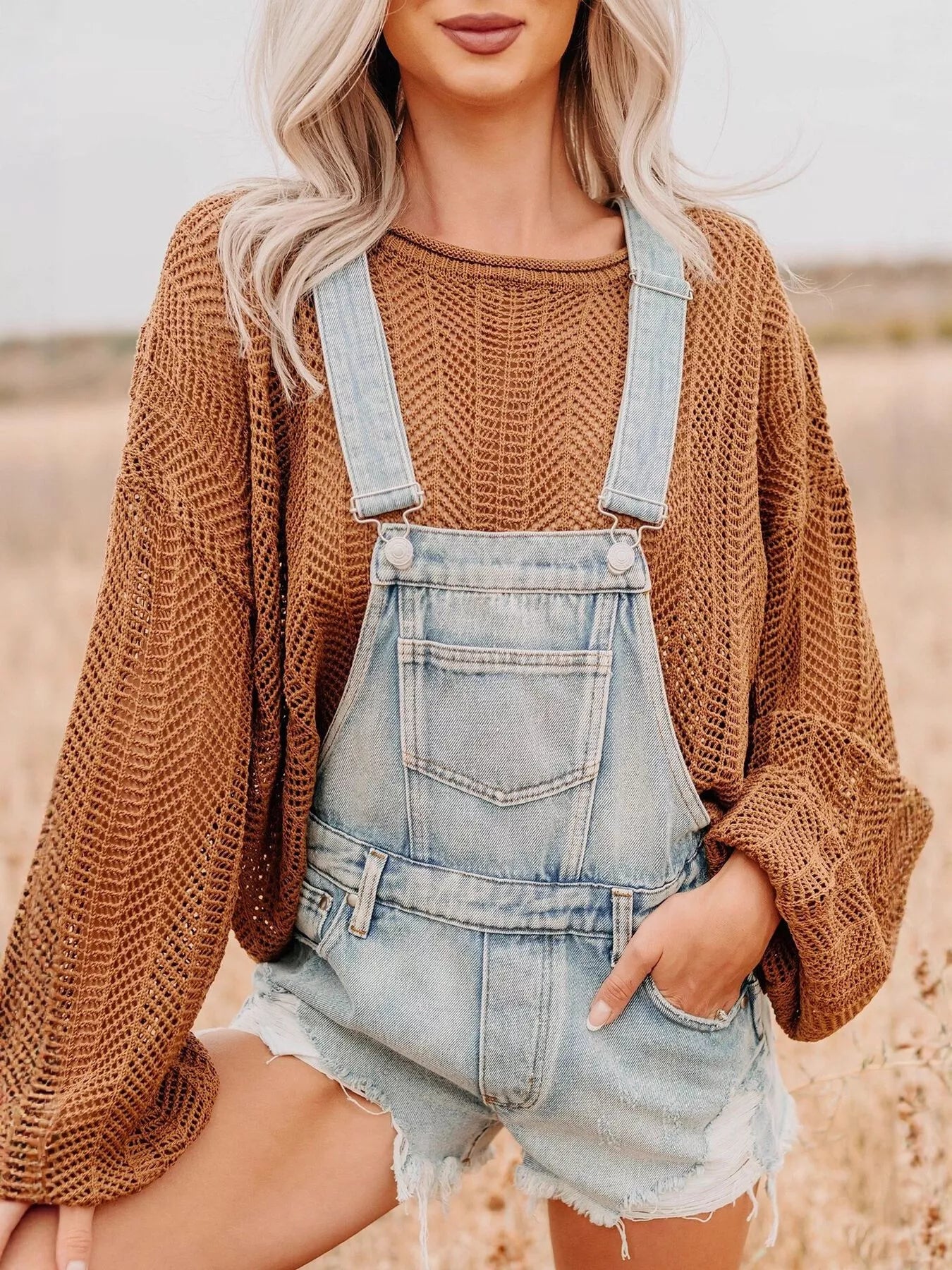 Distressed denim overalls shorts in light-wash with frayed hem and adjustable straps