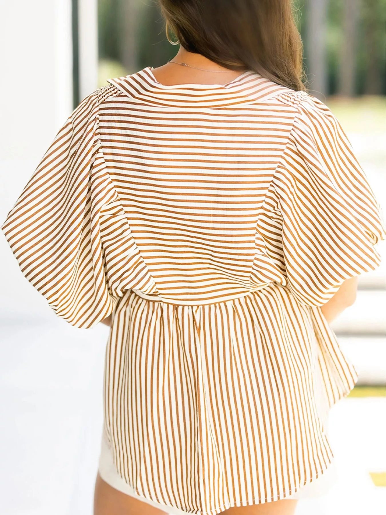 Woman in beige and brown striped V-neck puff sleeve blouse
