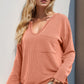 Soft peach ribbed knit V-neck long-sleeve top with front pocket