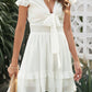White chiffon tie-front mini dress with ruffled sleeves and smocked waistband