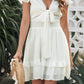 White tie-front mini dress with smocked waist and ruffled skirt