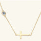 Gold necklace with a small round moissanite stone and a gold horizontal cross pendant on a white background