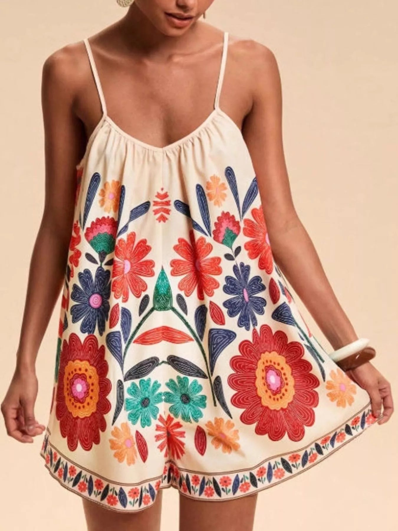 Floral print spaghetti strap romper in vibrant off-white with embroidered blossoms