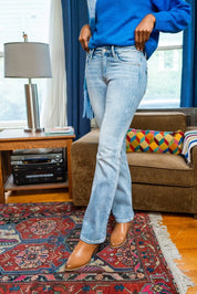 Judy Blue mid-rise thermal bootcut jeans in light blue denim with relaxed fit and brown leather boots