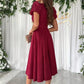 Woman in burgundy Surplice Short Sleeve Midi Dress with puffed sleeves