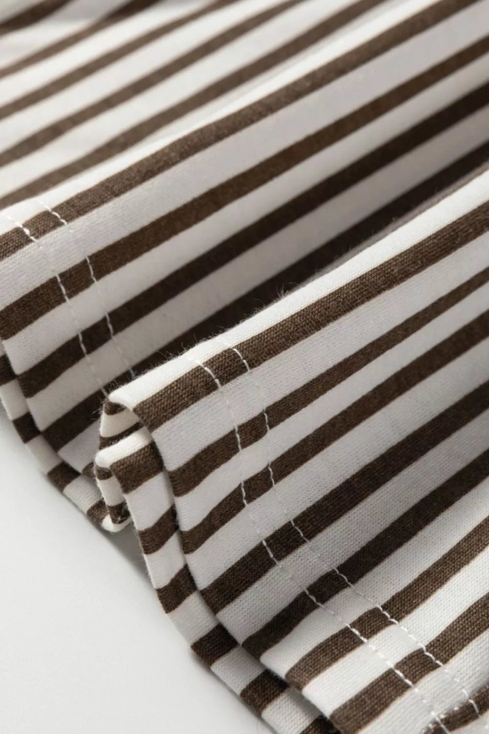 Brown and white striped elastic high waist pocketed loose pants fabric close-up
