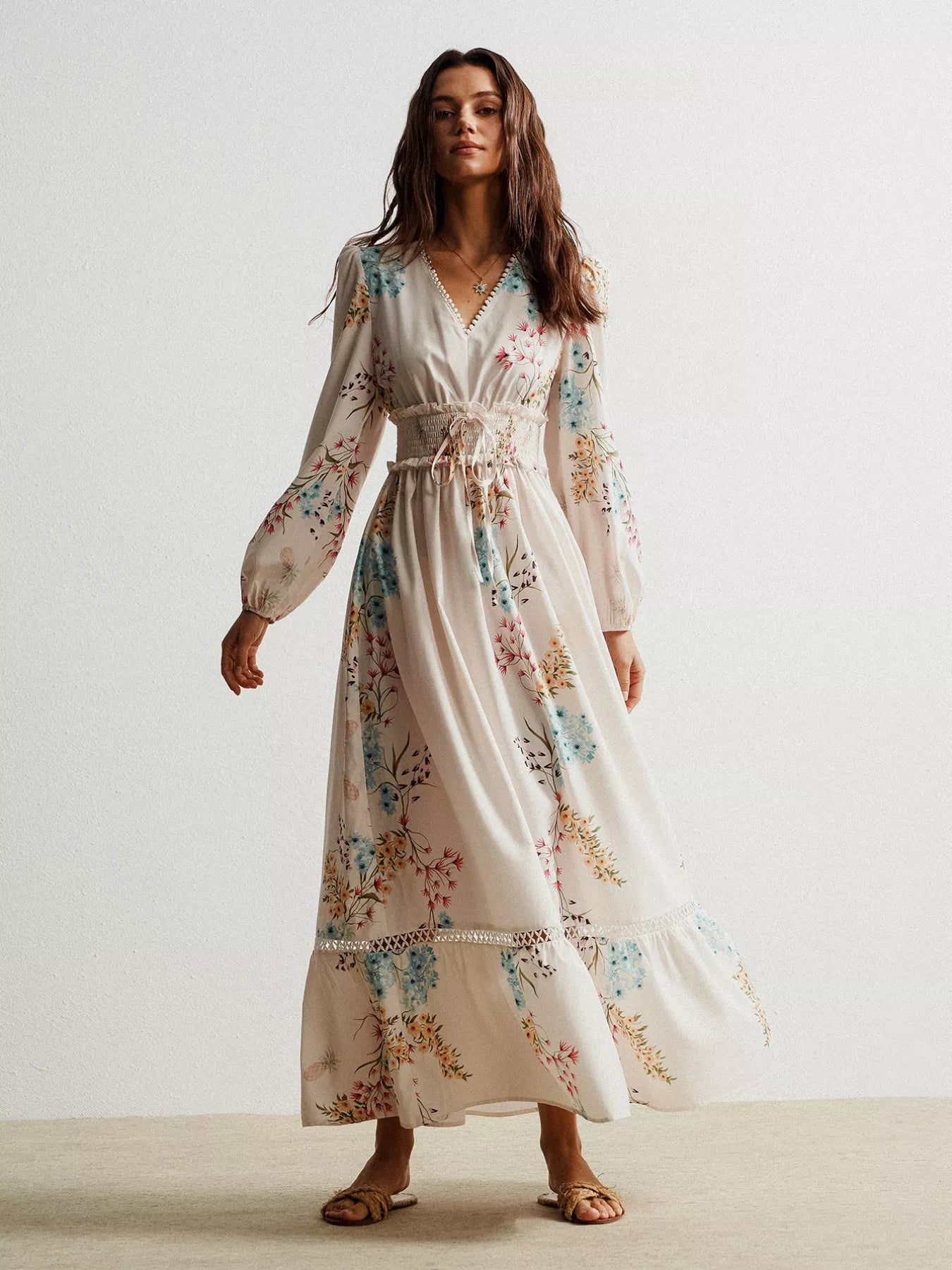 Flowing off-white floral maxi dress with long sleeves and smocked waist